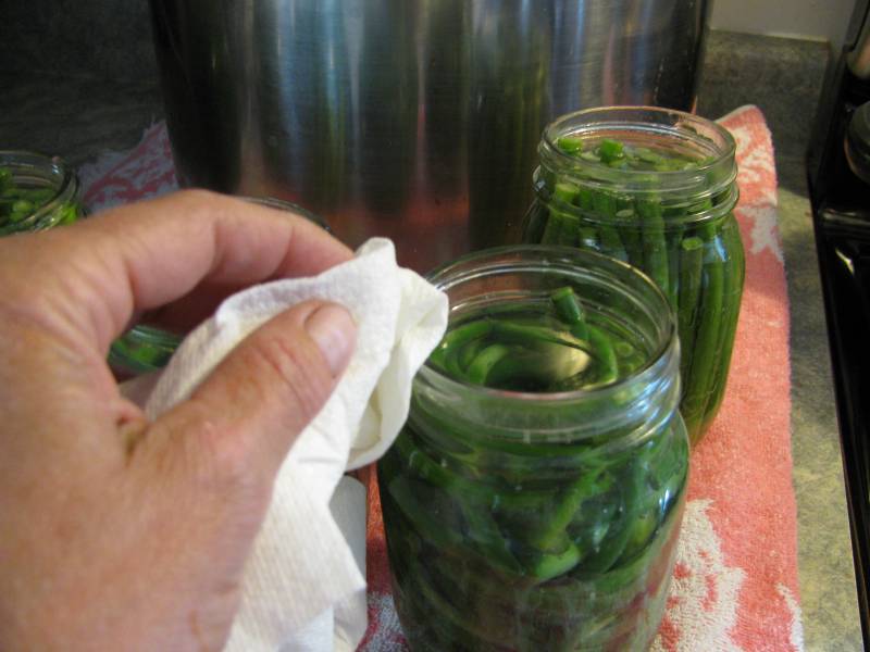 WIping down the rim of a jar.