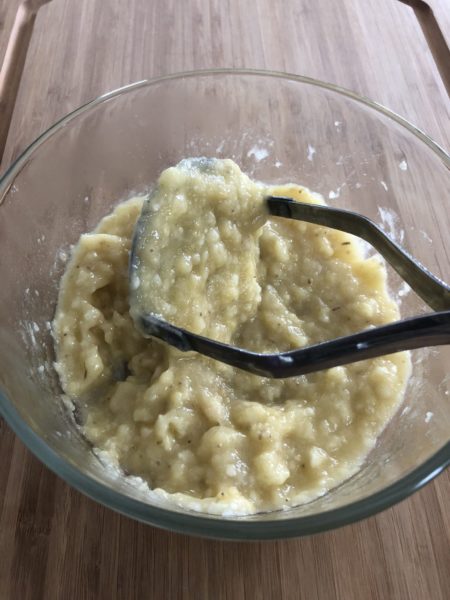 Mashed bananas in a clear bowl.