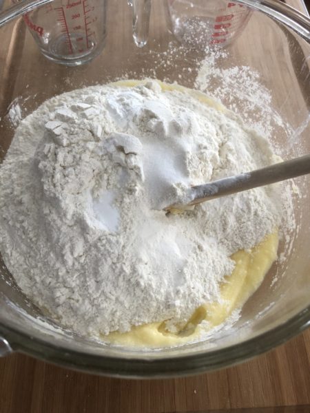 Wet and dry ingredients for banana bread in a clear bowl.