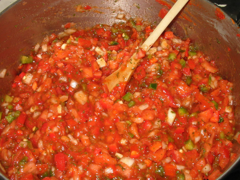 Fresh ingredients are on the stove for chunky salsa recipe for canning