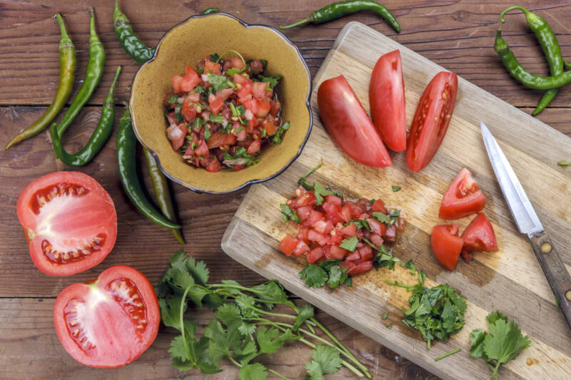 Salsa ingredients on a wooden chopping board.