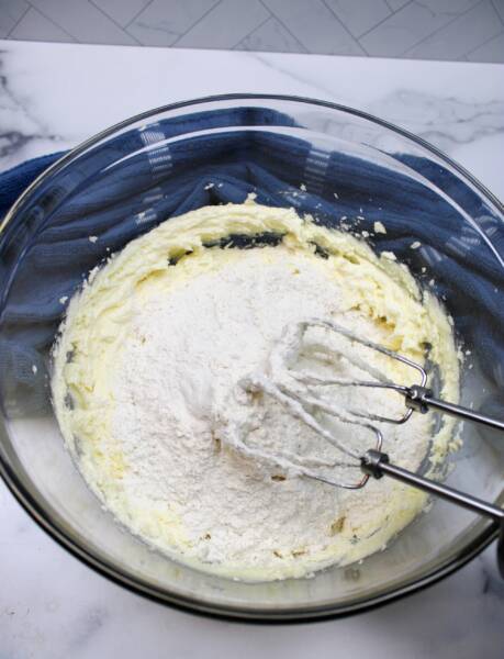 Adding flour to butter and sugar mixture.