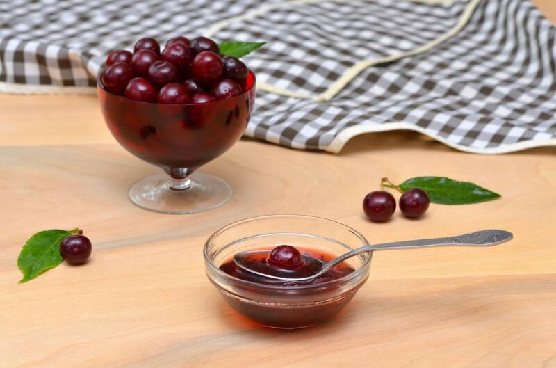 Can cherries in a bowl on a table.