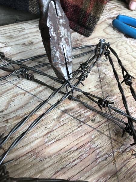 using pliers to shape barbed wire star