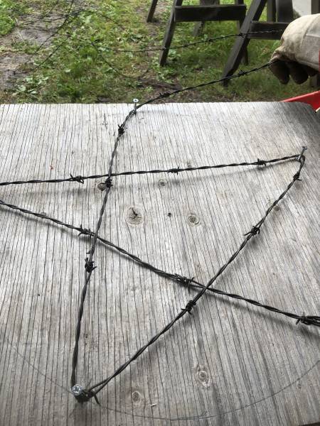 metal barbed wire being formed into a star shape