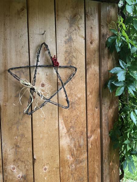 Metal barbed wire star hanging on a wood wall
