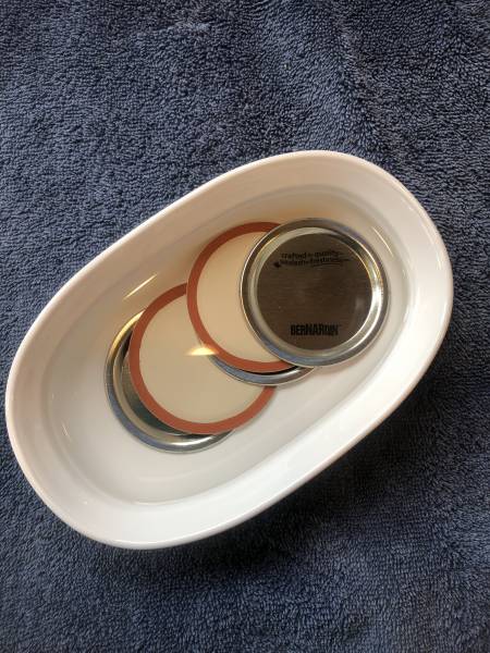 Canning seals are sitting in a bowl of hot water prior to using.
