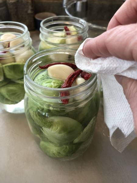 Wiping the jar rims before they go in the canner