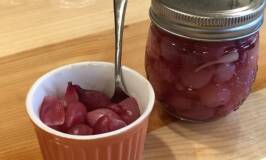 a small bowl of pickled onions and a jar of onions sit on the counter