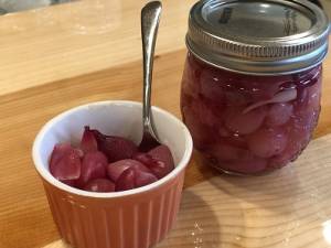 a small bowl of pickled onions and a jar of onions sit on the counter