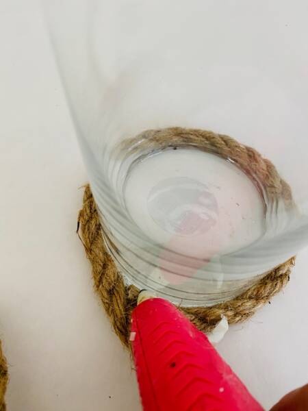 Wind rope around the candle pressing it into the glue.