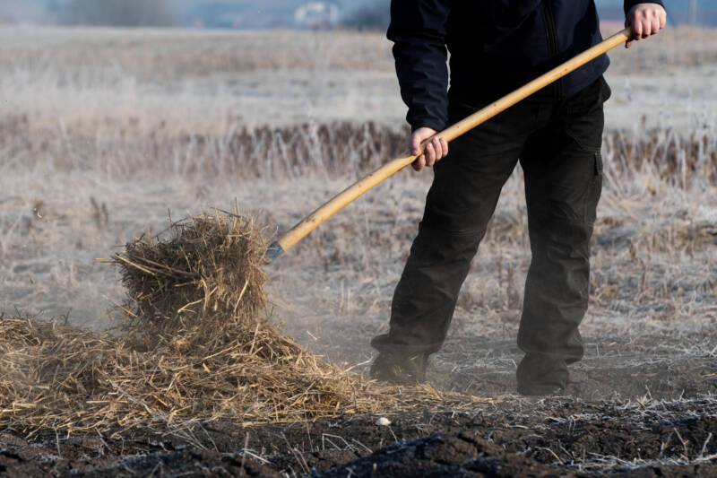 adding mulch to cover a garden bed