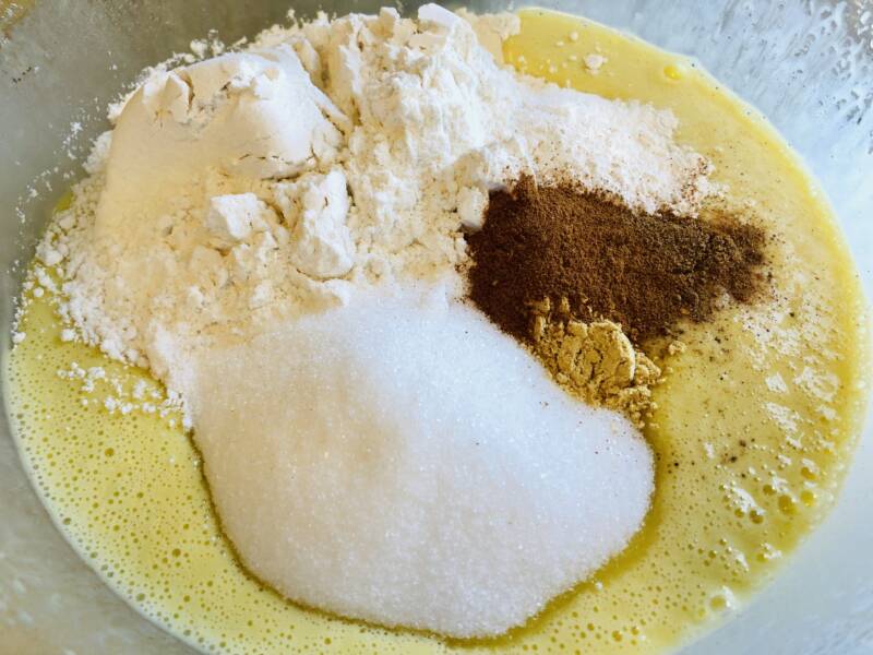 Mixing together the eggs, oil, spices, sugar and flour for muffins