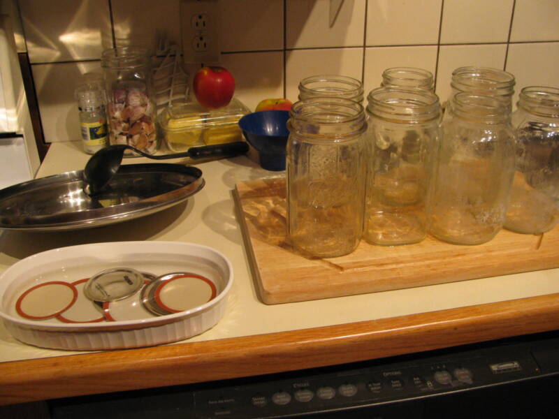 Canning tips: Lots of empty jars and seals sitting on a counter.