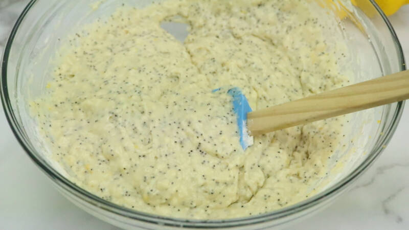 Mixing muffin batter in a glass bowl.