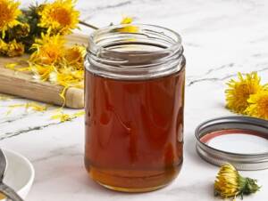 Dandelion Syrup in an open jar ready for spooning onto pancakes.