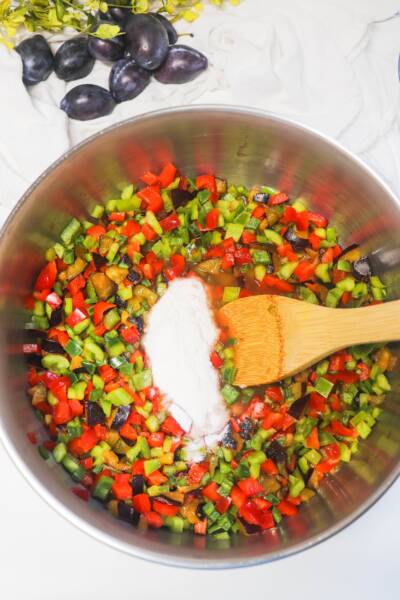 Adding pectin to the large pot containing the other pepper jelly ingredients.