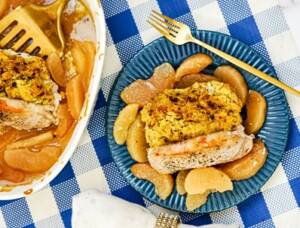Stuffed pork chops and apple pie filling on a blue pate.